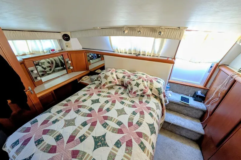 Gloryb2god Yacht Photos Pics Cozy bedroom interior of 1990 Carver 55 yacht with quilted bedding and wooden cabinetry.