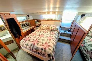 Gloryb2god Yacht Photos Pics Cozy bedroom interior of 1990 Carver 55 yacht with quilted bedspread and wooden cabinetry.