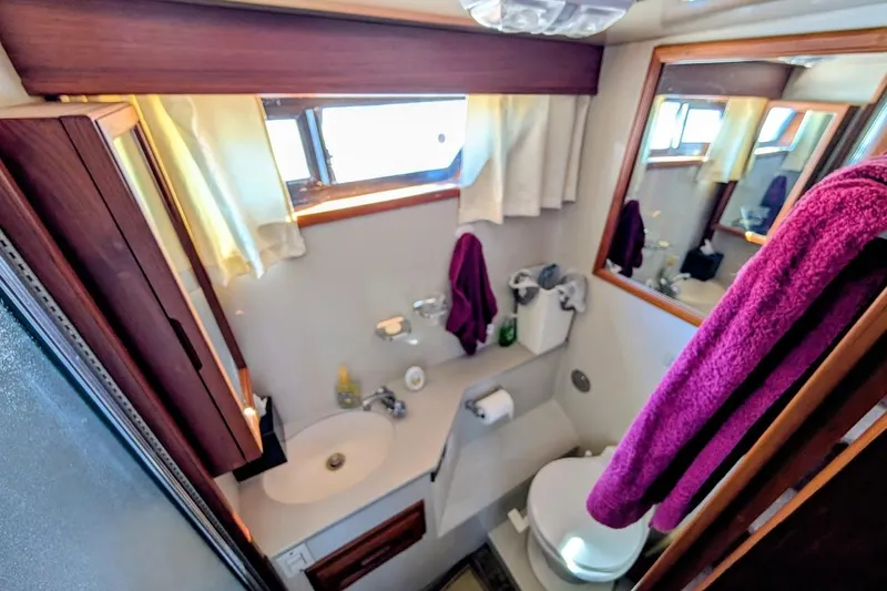 Gloryb2god Yacht Photos Pics Bathroom interior of a 1990 Carver 55 yacht, featuring sink, toilet, and mirror.