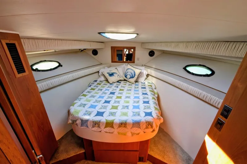 Gloryb2god Yacht Photos Pics 1990 Carver 55 yacht bedroom with cozy bed, decorative pillows, and porthole windows.