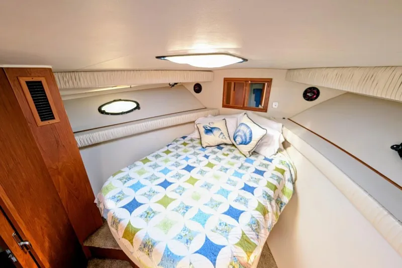 Gloryb2god Yacht Photos Pics Cozy bedroom in 1990 Carver 55 yacht with nautical-themed bedding and wooden accents.
