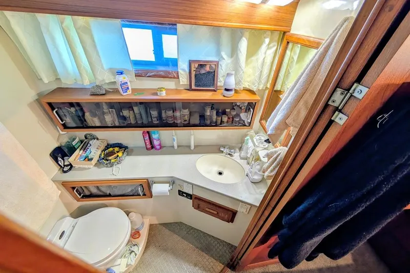 Gloryb2god Yacht Photos Pics Bathroom interior of a 1990 Carver 55 yacht, featuring sink, toiletries, and storage.