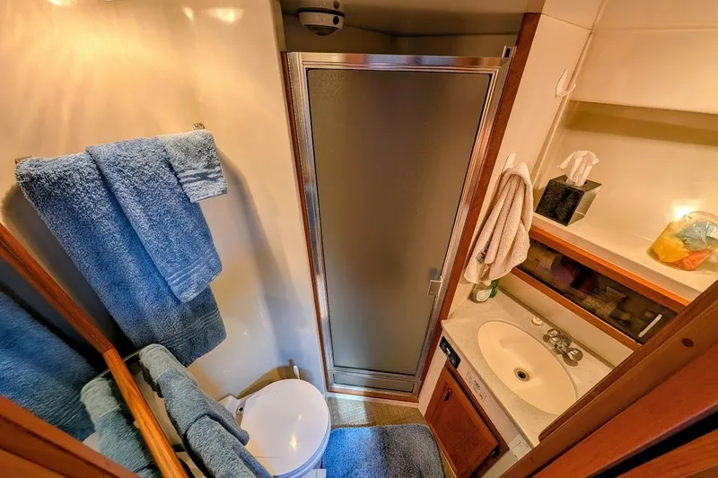 Gloryb2god Yacht Photos Pics Compact bathroom in 1990 Carver 55 yacht with shower, sink, and blue towels.