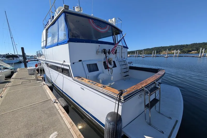 Gloryb2god Yacht Photos Pics 1990 Carver 55 yacht docked at marina, featuring spacious deck and blue canopy.