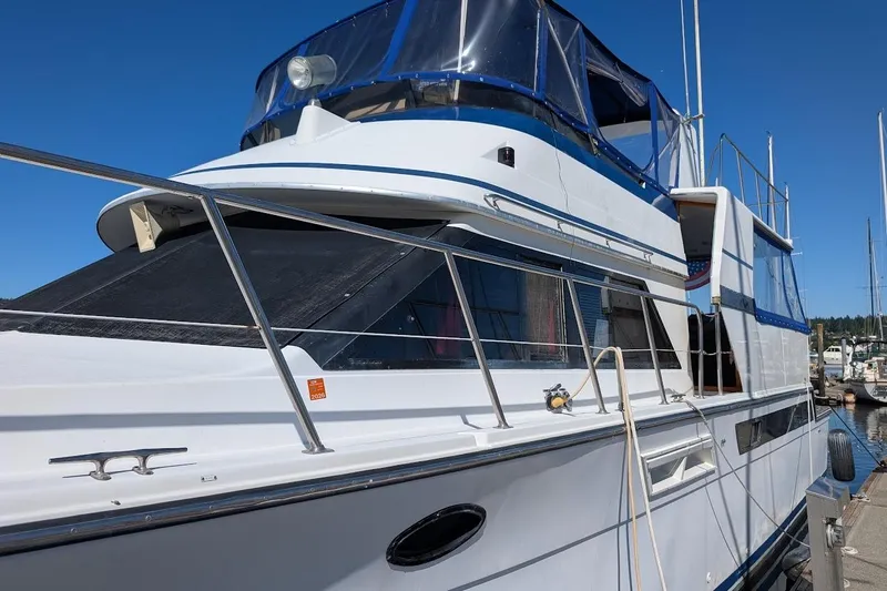 Gloryb2god Yacht Photos Pics 1990 Carver 55 yacht docked, featuring sleek design and blue accents under clear sky.