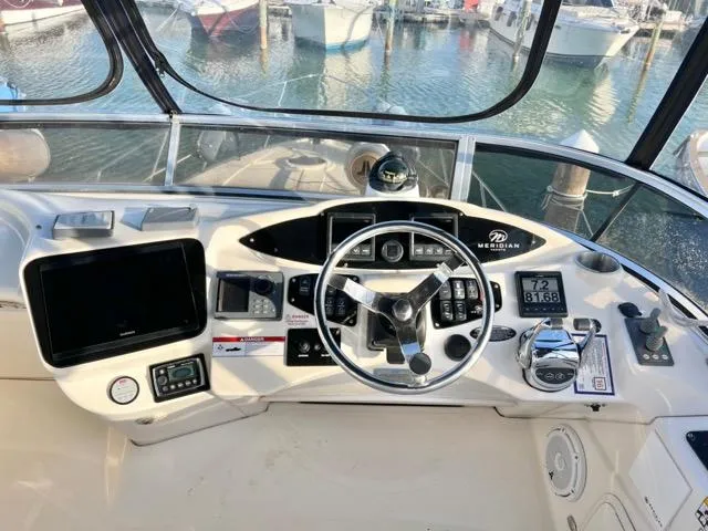  Yacht Photos Pics 2009 Meridian 391 Sedan helm with steering wheel, navigation controls, and marina view.
