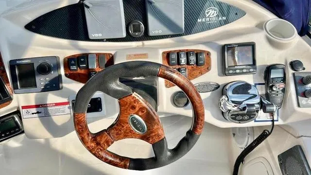  Yacht Photos Pics 2009 Meridian 391 Sedan helm with wood-accented steering wheel and navigation controls.
