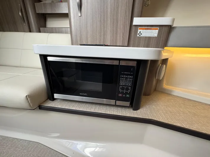 C Life Yacht Photos Pics Microwave in 2021 Regal 36 XO yacht interior, featuring modern cabinetry and seating.