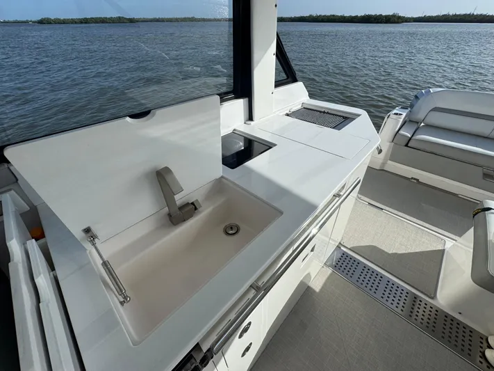 C Life Yacht Photos Pics 2021 Regal 36 XO yacht interior with sink and seating, overlooking serene water.