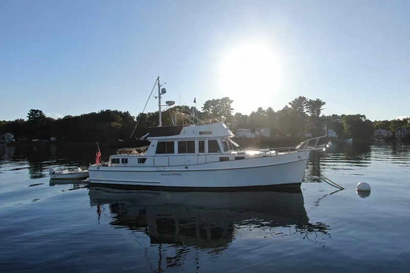 Maximon Yacht Photos Pics 1989 Grand Banks 46 Classic yacht on calm water at sunset.