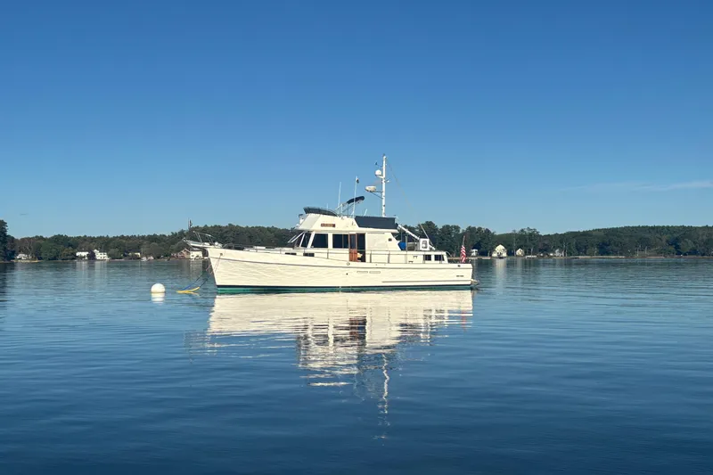 Maximon Yacht Photos Pics 1989 Grand Banks 46 Classic yacht on calm water under clear blue sky.