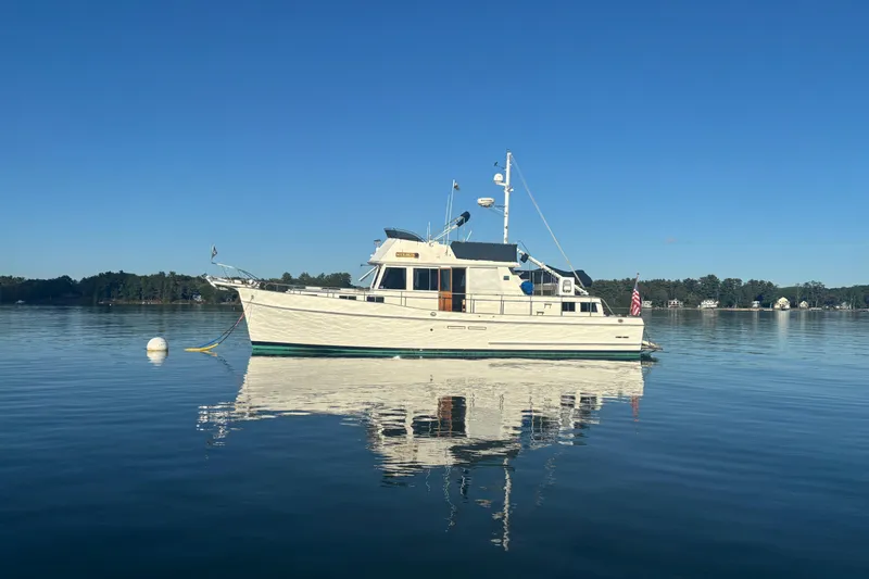 Maximon Yacht Photos Pics 1989 Grand Banks 46 Classic yacht on calm water under clear blue sky.