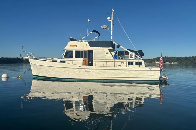 Maximon Yacht Photos Pics 1989 Grand Banks 46 Classic yacht on calm water, clear sky reflection.