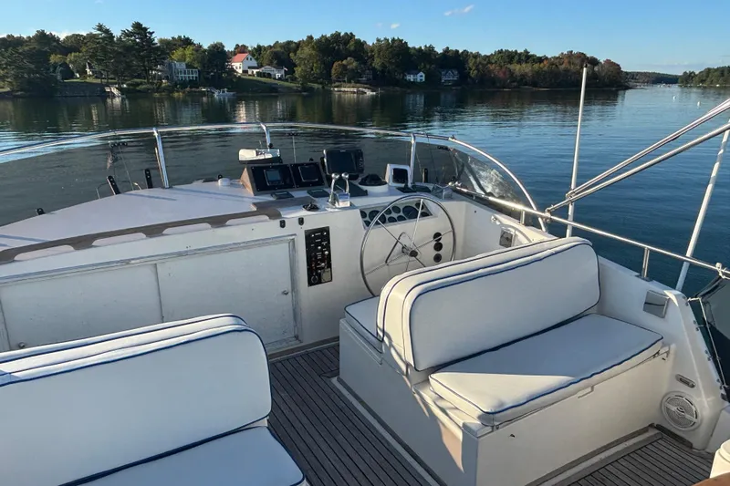 Maximon Yacht Photos Pics 1989 Grand Banks 46 Classic yacht helm with seating, overlooking serene water and shoreline.