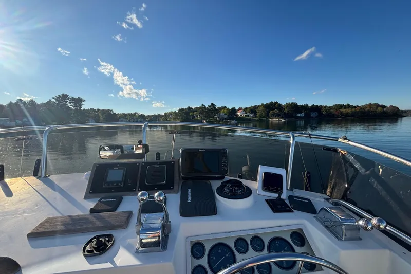 Maximon Yacht Photos Pics Helm of 1989 Grand Banks 46 Classic yacht with navigational instruments, overlooking calm waters.
