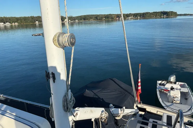 Maximon Yacht Photos Pics 1989 Grand Banks 46 Classic yacht on serene lake with American flag and small boat.