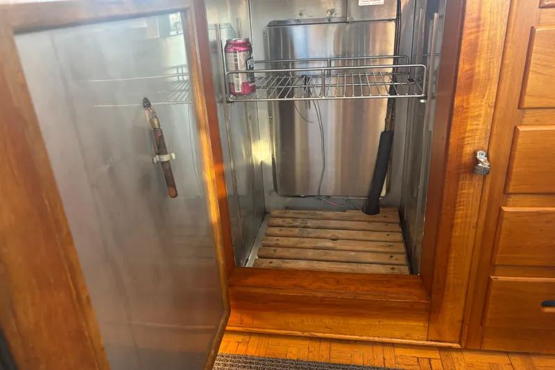 Maximon Yacht Photos Pics Open wooden cabinet on 1989 Grand Banks 46 Classic yacht, showing interior storage space.