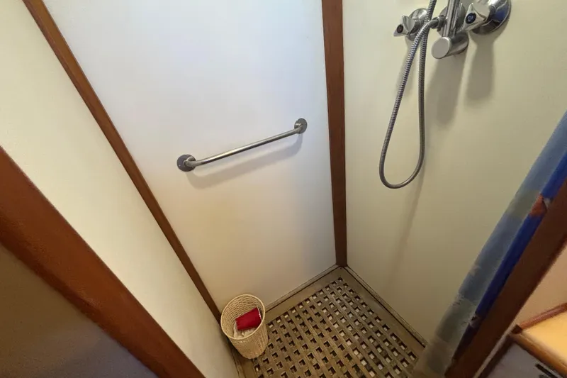 Maximon Yacht Photos Pics Shower area in 1989 Grand Banks 46 Classic yacht with wooden floor and metal fixtures.