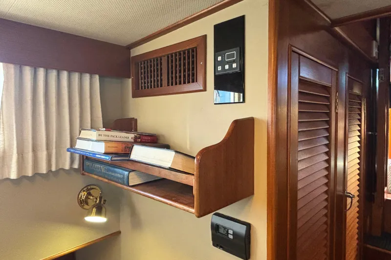 Maximon Yacht Photos Pics 1989 Grand Banks 46 Classic interior with bookshelf, wooden paneling, and wall-mounted controls.