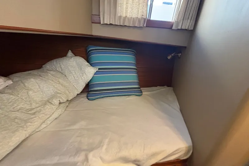 Maximon Yacht Photos Pics Cozy cabin bed with striped pillow on 1989 Grand Banks 46 Classic yacht.