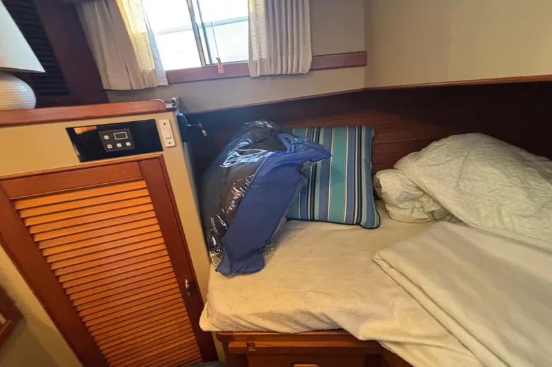 Maximon Yacht Photos Pics Cozy cabin interior of 1989 Grand Banks 46 Classic yacht with bed and striped pillows.