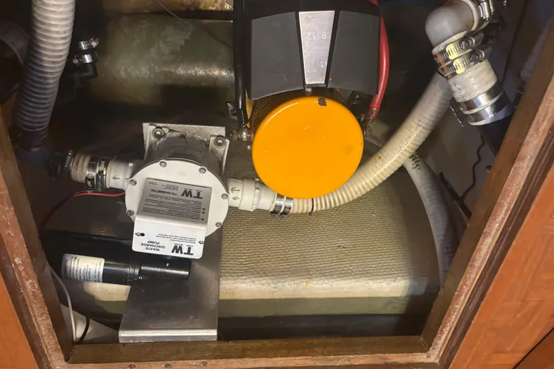 Maximon Yacht Photos Pics Engine compartment of a 1989 Grand Banks 46 Classic boat with visible pump and hoses.