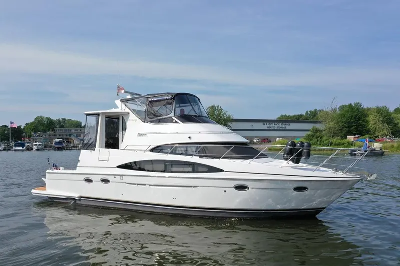  Yacht Photos Pics 2003 Carver 444 Cockpit Motor Yacht on calm water, with marina background.