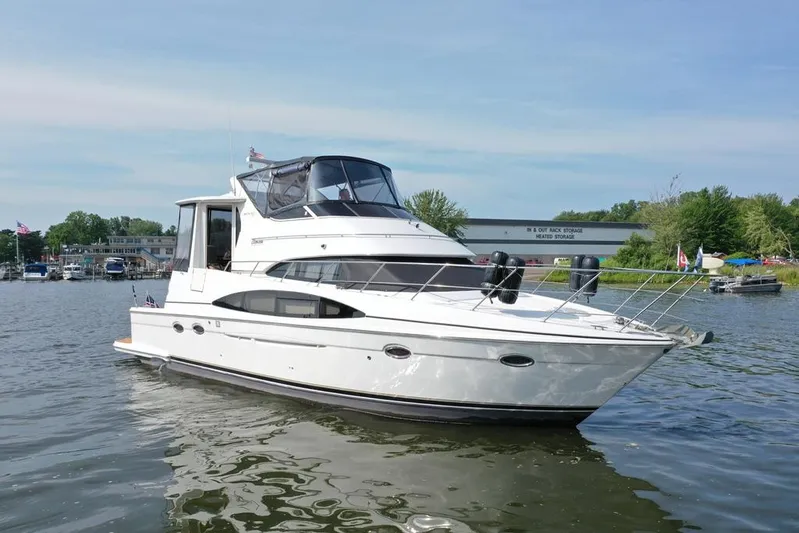  Yacht Photos Pics 2003 Carver 444 Cockpit Motor Yacht on a serene lake with marina backdrop.
