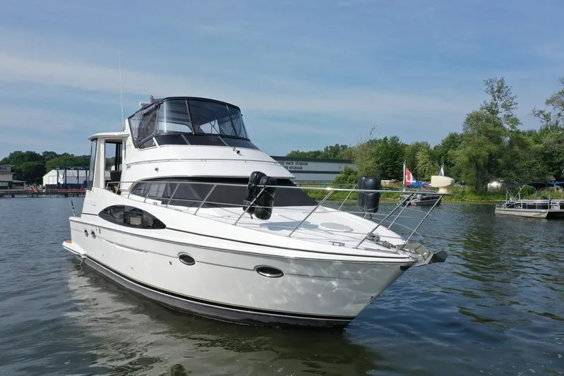  Yacht Photos Pics 2003 Carver 444 Cockpit Motor Yacht on calm water, surrounded by greenery.
