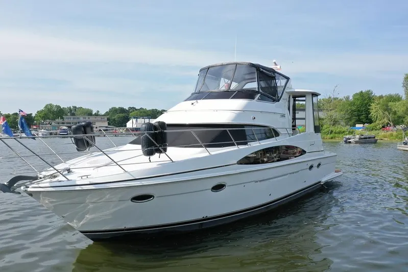  Yacht Photos Pics 2003 Carver 444 Cockpit Motor Yacht on a serene lake, surrounded by lush greenery.