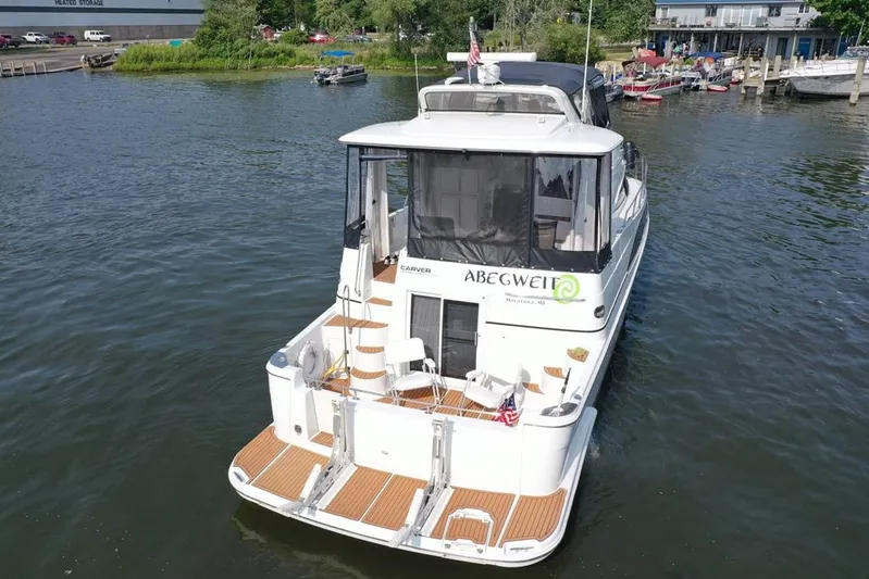  Yacht Photos Pics 2003 Carver 444 Cockpit Motor Yacht on water, rear view, docked near marina.