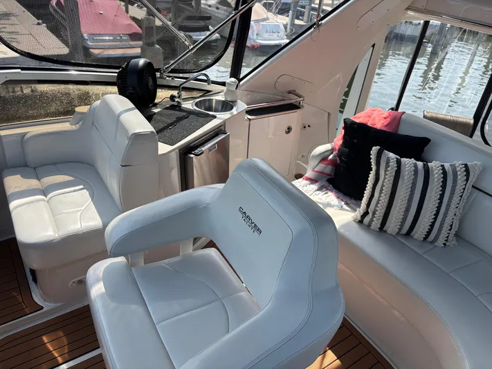  Yacht Photos Pics Interior of 2003 Carver 444 Cockpit Motor Yacht with white seating and striped pillows.