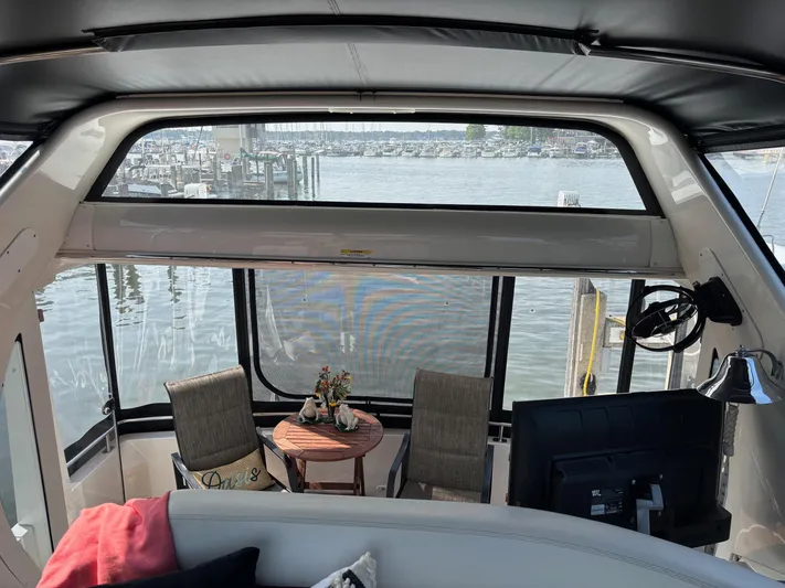  Yacht Photos Pics Interior view of 2003 Carver 444 Cockpit Motor Yacht with seating and marina backdrop.