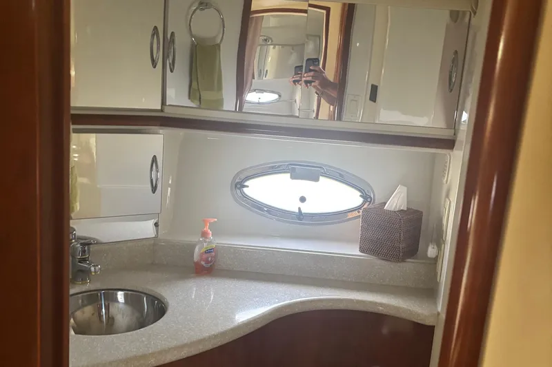  Yacht Photos Pics 2003 Carver 444 Cockpit Motor Yacht bathroom with sink, mirror, and porthole window.