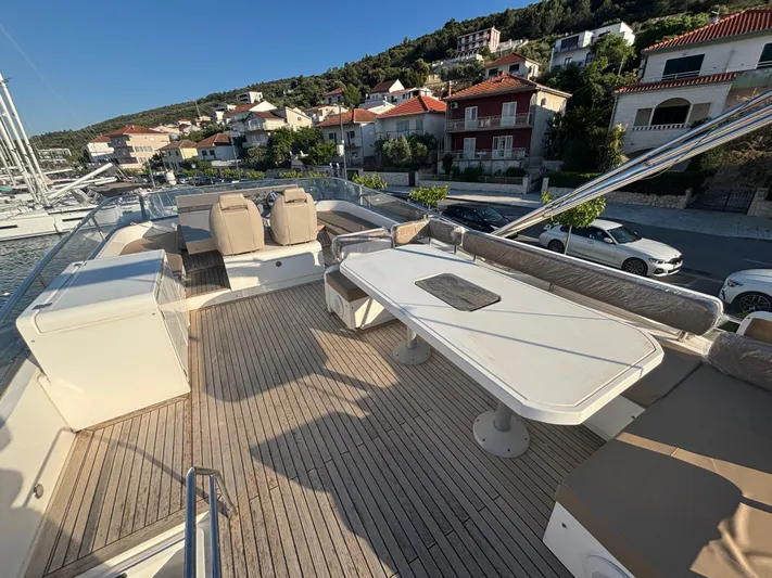  Yacht Photos Pics Flybridge of 2010 Fairline Squadron 65 yacht with seating and dining area, docked near waterfront homes.