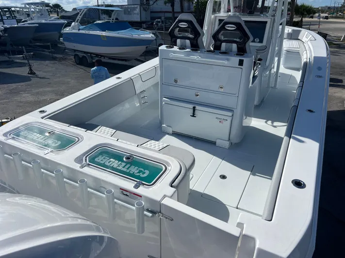  Yacht Photos Pics 2025 Contender 32 ST boat with dual seats and storage, docked outdoors.