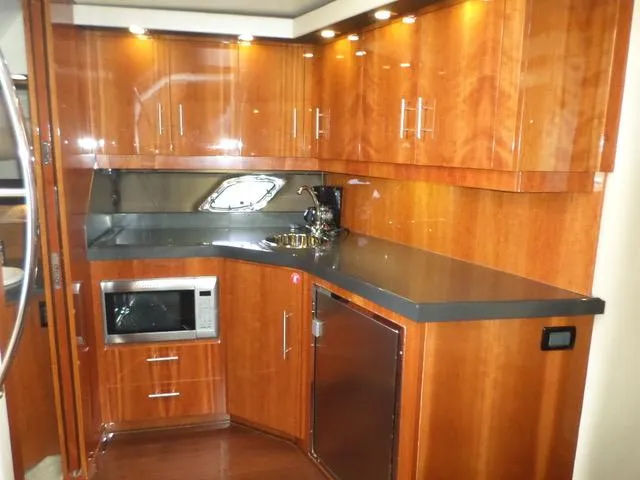 As Good As It Gets Yacht Photos Pics Luxurious kitchen area in a 2012 Regal 42 Sport Coupe yacht with wood cabinetry.