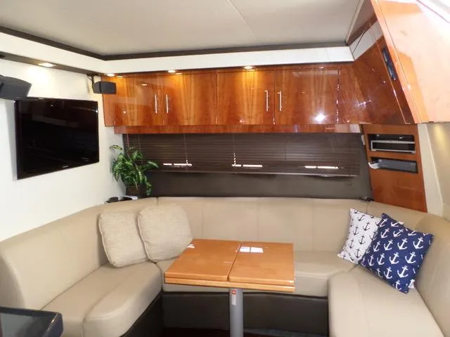 As Good As It Gets Yacht Photos Pics Interior of 2012 Regal 42 Sport Coupe with beige seating, wooden cabinets, and a TV.