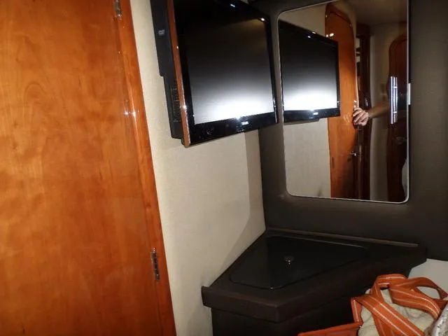 As Good As It Gets Yacht Photos Pics Interior of 2012 Regal 42 Sport Coupe with dual wall-mounted TVs and wooden cabinetry.