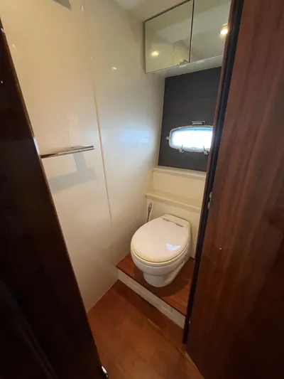  Yacht Photos Pics 2010 Fairline Squadron 65 yacht bathroom with toilet, wooden flooring, and storage cabinets.