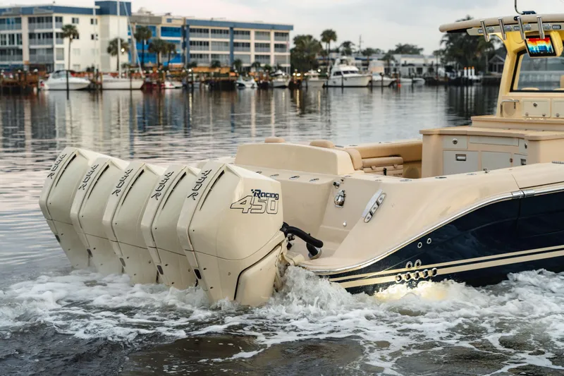 Yacht Photos Pics 2022 HCB 53 Sue&ntilde;os boat with multiple outboard engines on a calm waterfront.