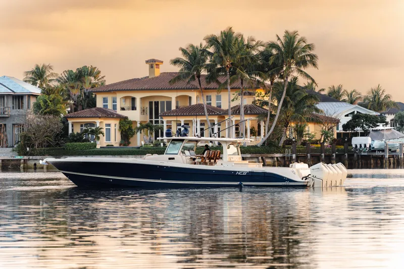 Yacht Photos Pics 2022 HCB 53 Sue&ntilde;os boat on calm water, luxury waterfront homes in background.