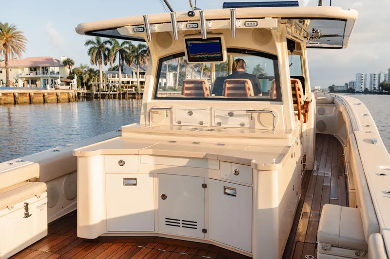  Yacht Photos Pics 2022 HCB 53 Sue&ntilde;os boat with luxurious deck and seating, docked near waterfront homes.