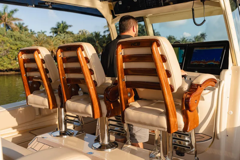  Yacht Photos Pics 2022 HCB 53 Sue&ntilde;os boat interior with luxurious wooden seating and modern navigation equipment.