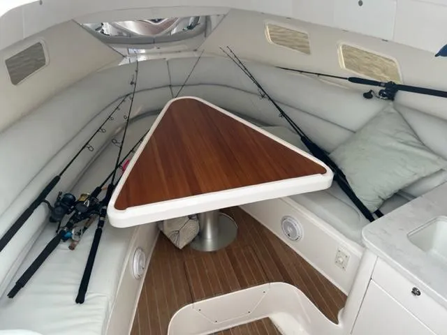  Yacht Photos Pics 2018 Intrepid 375 Walkaround cabin interior with fishing rods and triangular table.