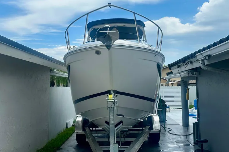  Yacht Photos Pics 2025 Regal 26 XO boat on trailer in driveway, under blue sky.