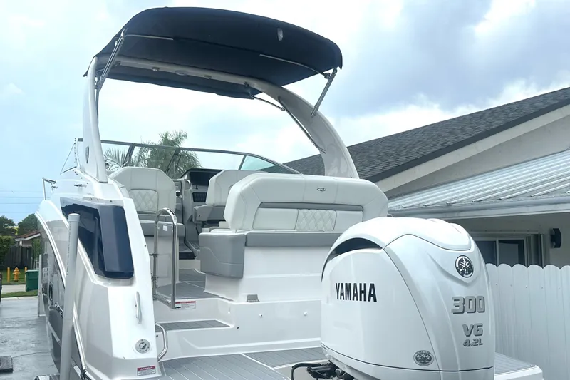  Yacht Photos Pics 2025 Regal 26 XO boat with Yamaha 300 V6 engine, docked near a house.
