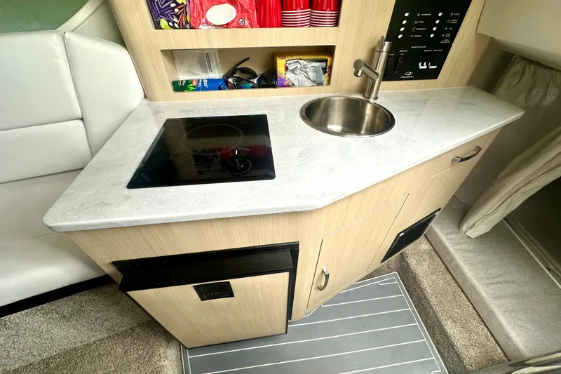  Yacht Photos Pics 2025 Regal 26 XO boat interior with kitchenette, featuring a sink and stovetop.