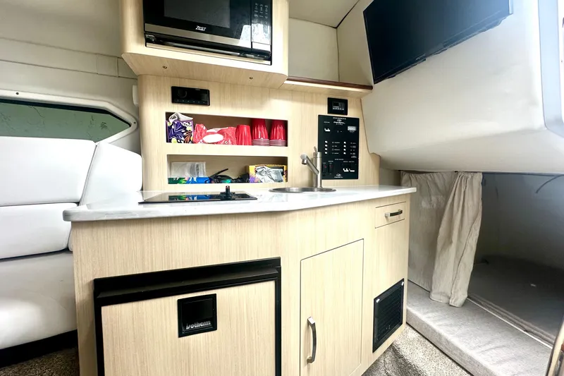  Yacht Photos Pics 2025 Regal 26 XO boat interior with kitchenette, microwave, and TV.