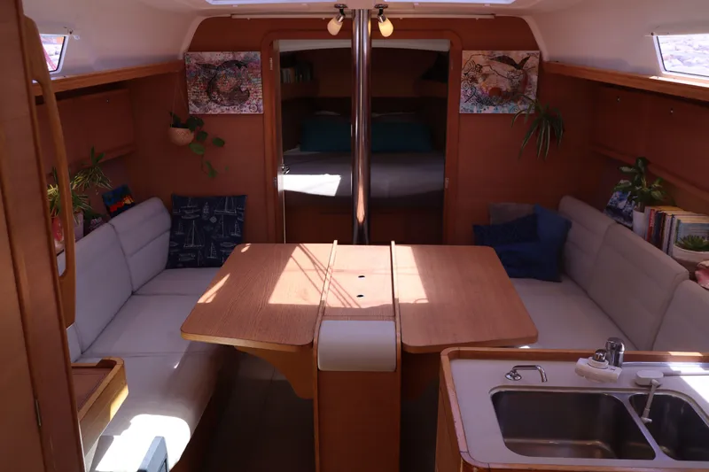  Yacht Photos Pics Interior of 2016 Dufour 382 Grand Large yacht with cozy seating and wooden table.